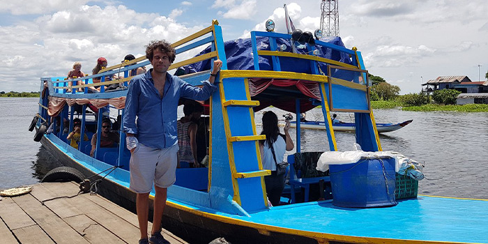 tourist-taking-a-photo-with-a-blue-boat