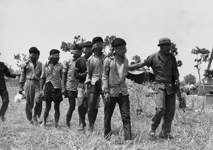 a-south-vietnamese-soldier-takes-a-group-of-blindfolded-khmer-rouge-prisoners-to-an-interrogation-center-in-kompong-trach-cambodia-in-1972