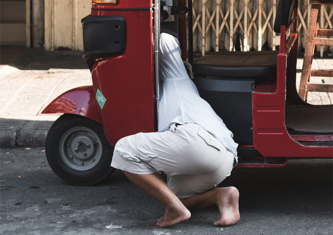 a-cambodian-driver-is-repairing-his-red-tuk-tuk