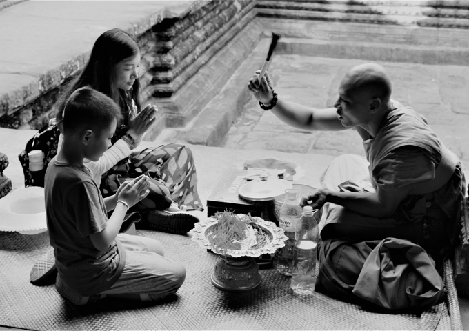 mom-and-son-are-praying-for-a-good-future-under-a-monks-sermon